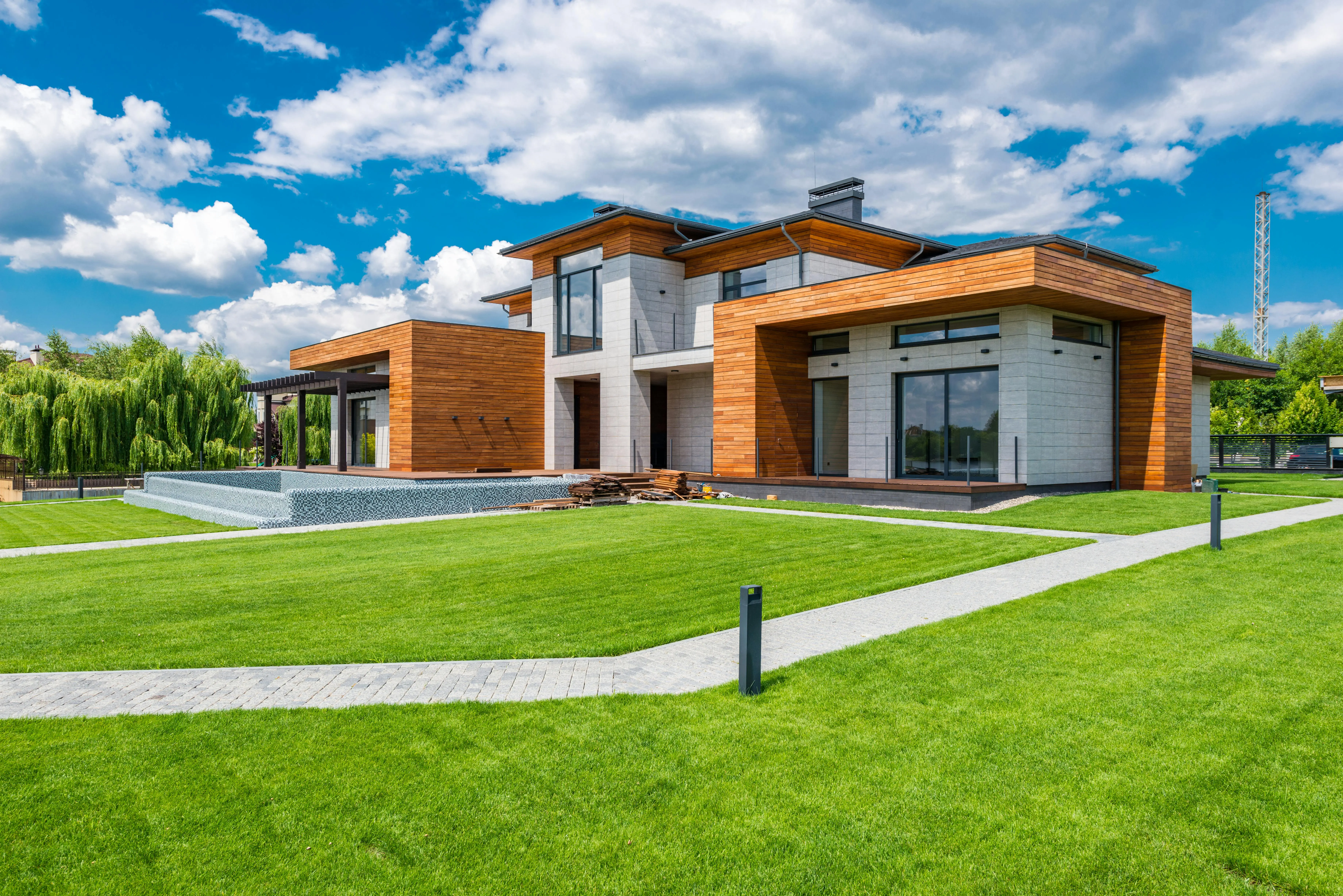 Modern home landscaping project with bright blue sky and clouds in background. Sakatchewan.