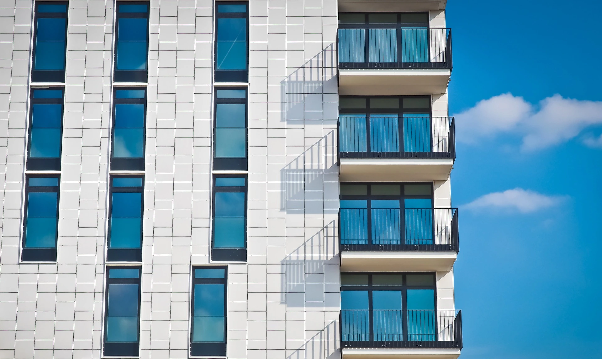 Side of white apartment build with bright blue sky in background. Saskatchewan.