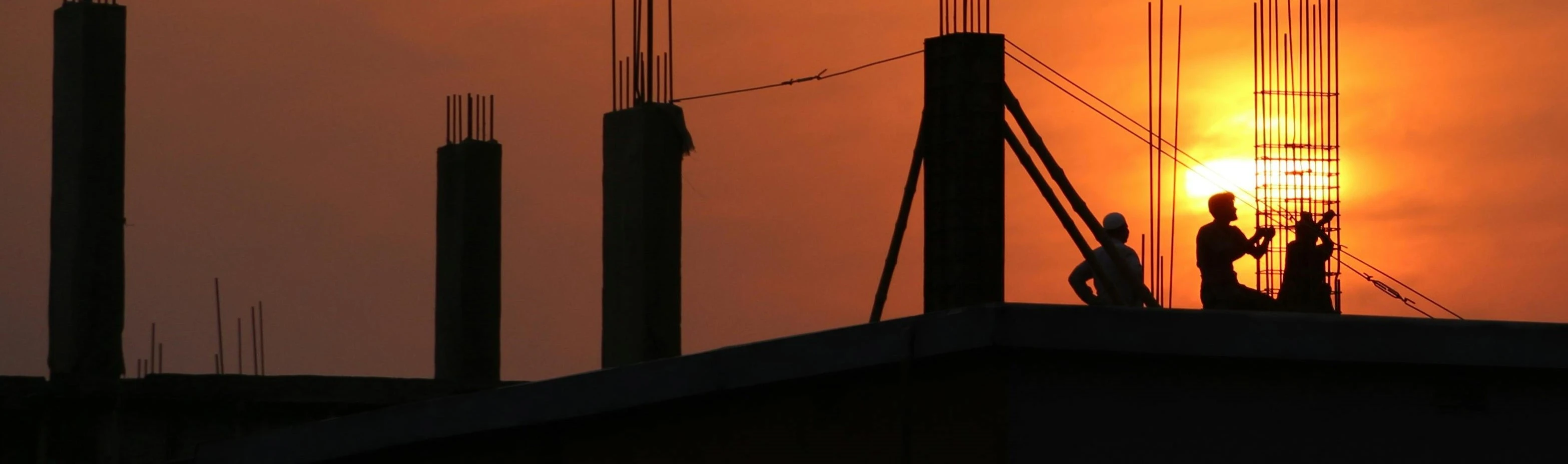 Workers on a roof with sunset in background. Saskatchewan.